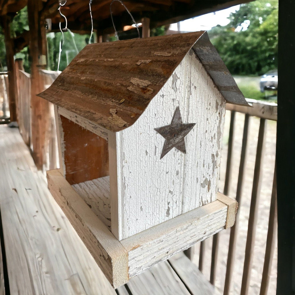 Rustic white wooden birdfeeder with a tin roof and star on both ends. Tray for easy feeding.