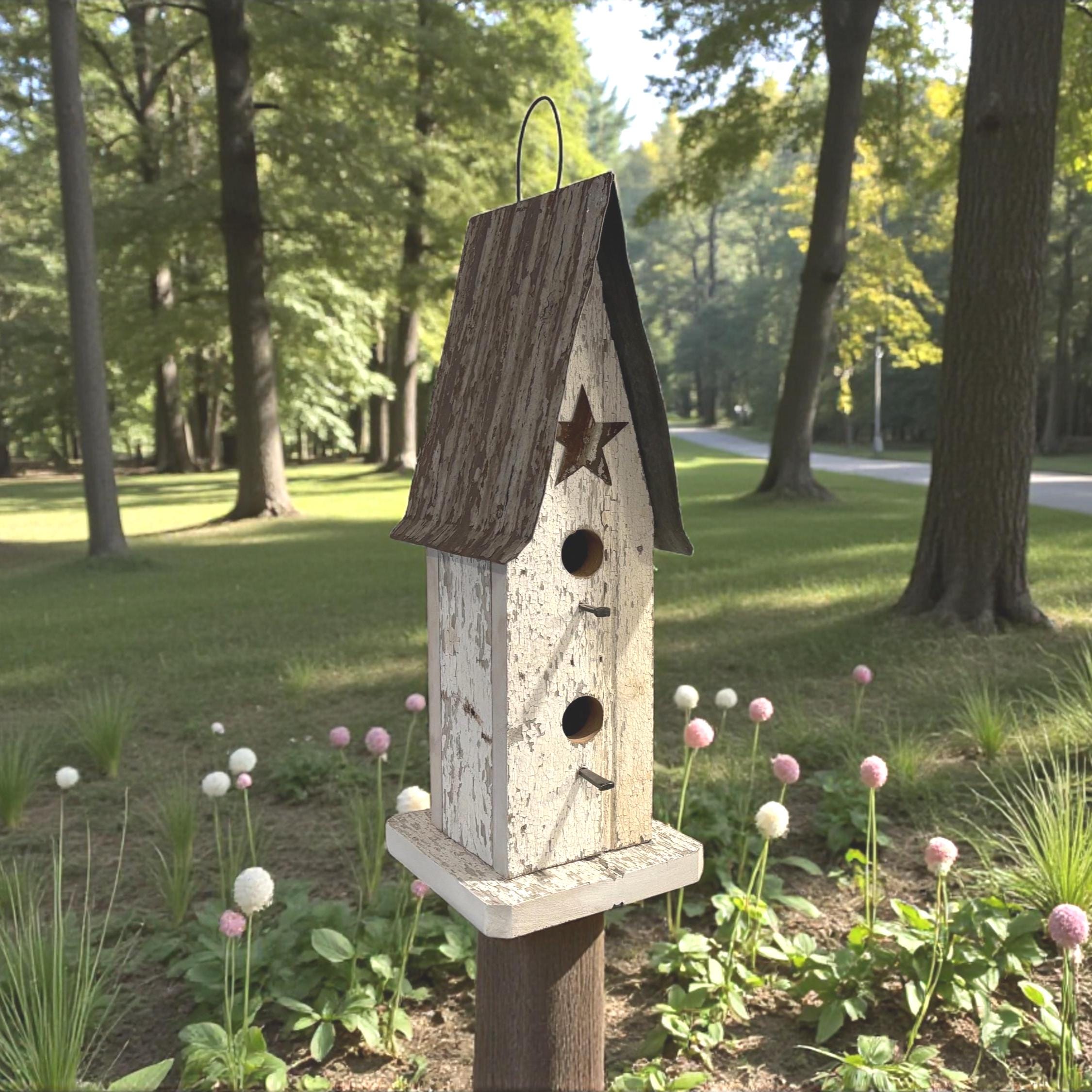 Wooden birdhouse with a star design on a wooden post in a garden setting with trees and flowers.