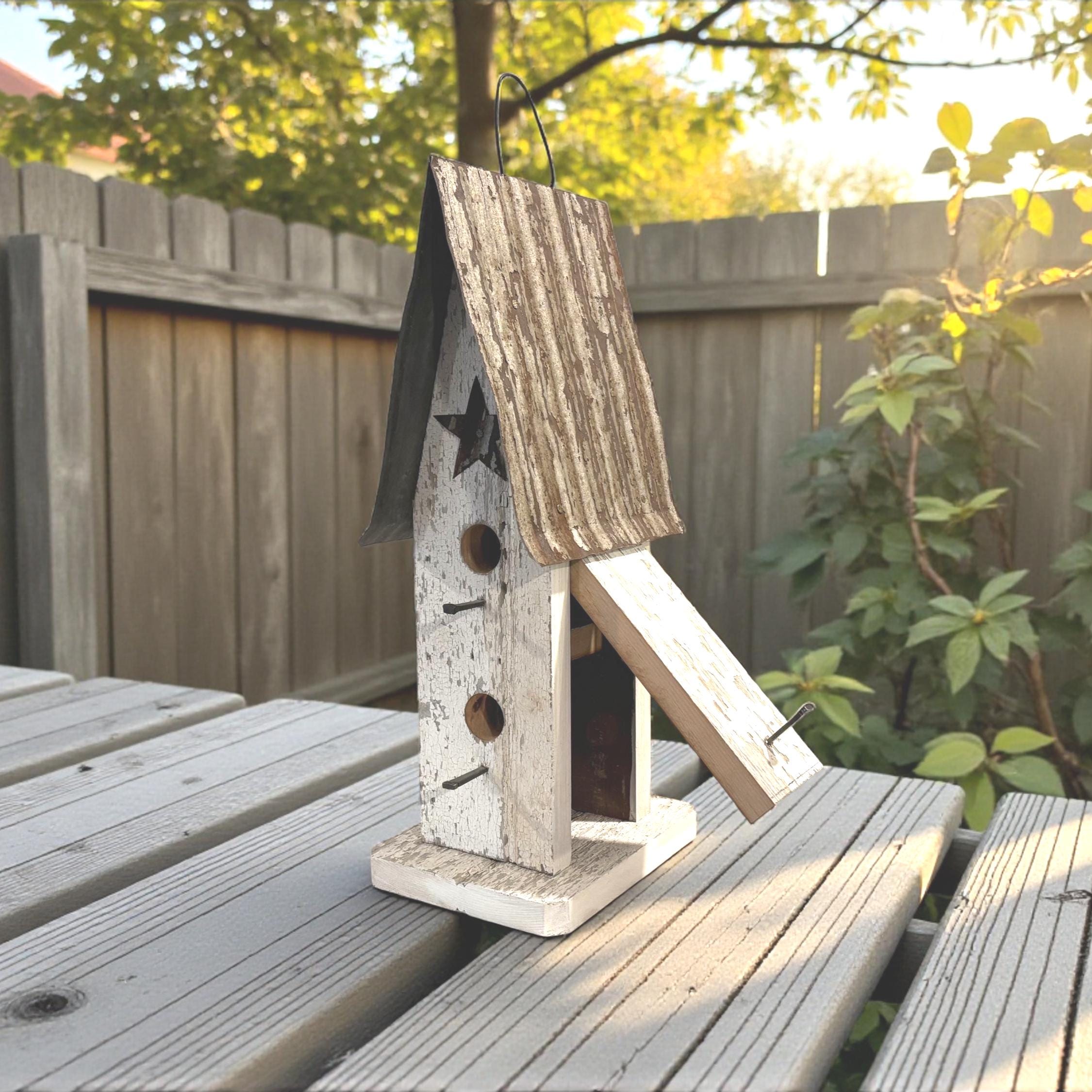 Wooden birdhouse with a star design on a wooden deck