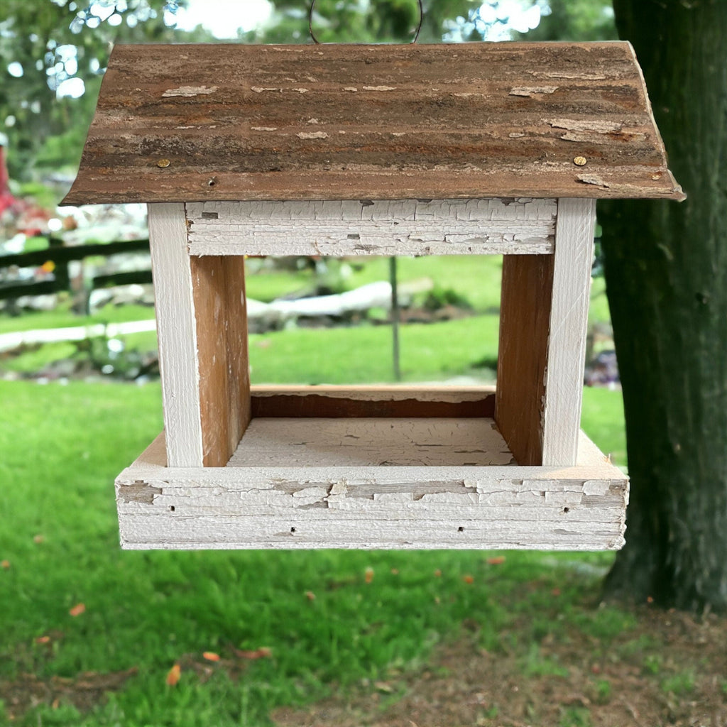 Rustic white wooden birdfeeder with a tin roof and star on both ends. Tray for easy feeding.